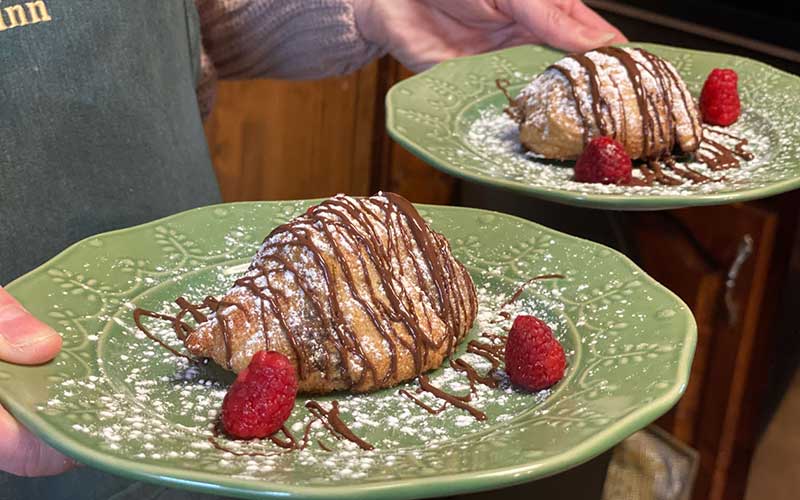 banana crescents with chocolate syrup, powdered sugar, and strawberries